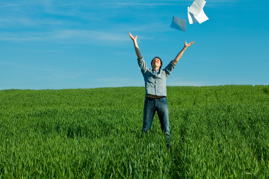 happy man throws papers in field