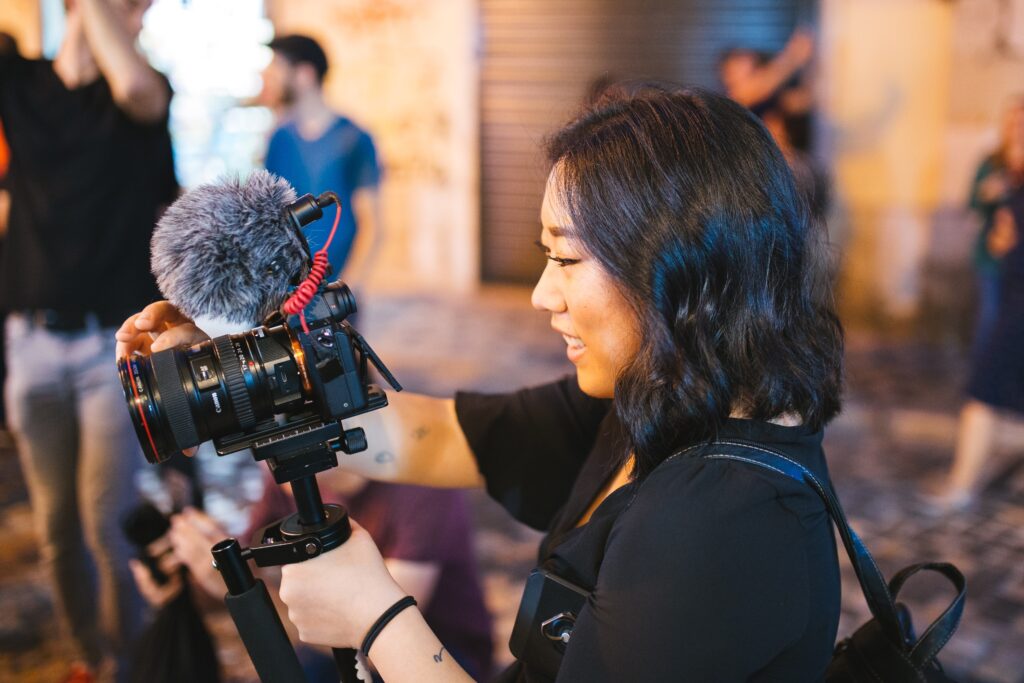 A stock image of a journalist capturing a story with her DSLR camera with a mic on top. This is to demonstrate the different types of journalism careers available