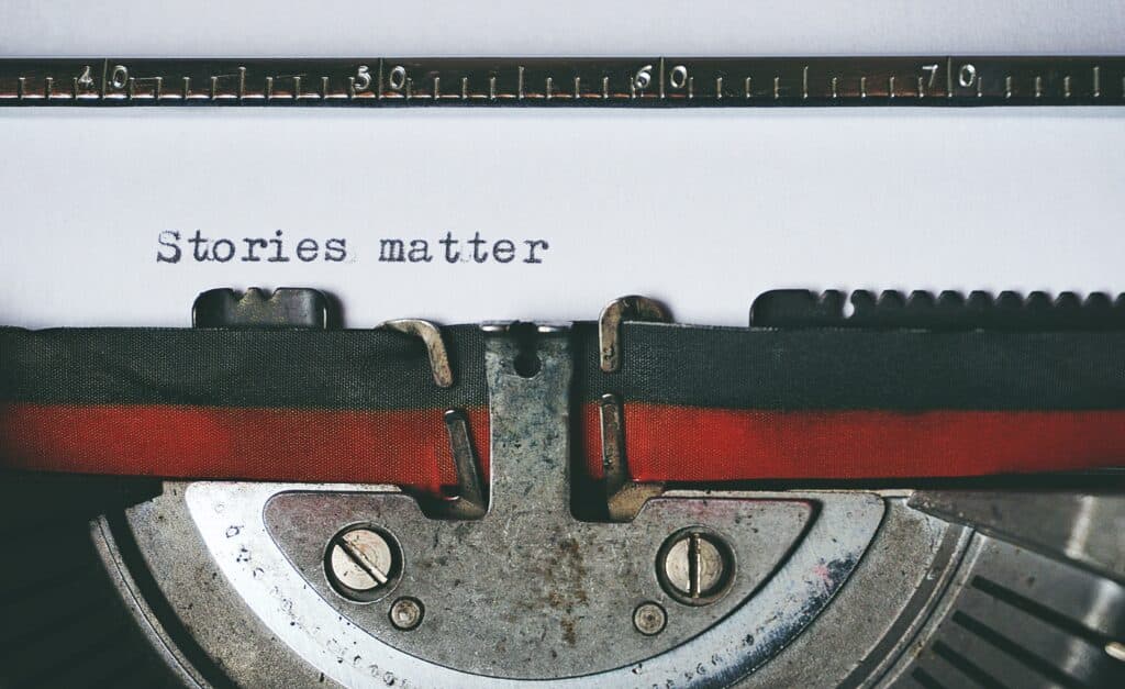 A close-up photo of a typewriter with the text reading Stories Matter. It's to illustrate the importance of story when vying for entry level grant writing jobs